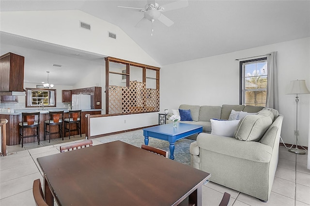 living room featuring sink, high vaulted ceiling, light tile patterned floors, and ceiling fan with notable chandelier