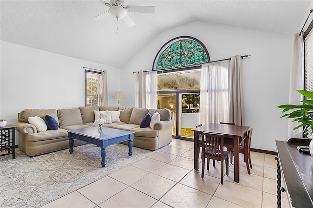 living room featuring lofted ceiling, a textured ceiling, light tile patterned floors, and ceiling fan