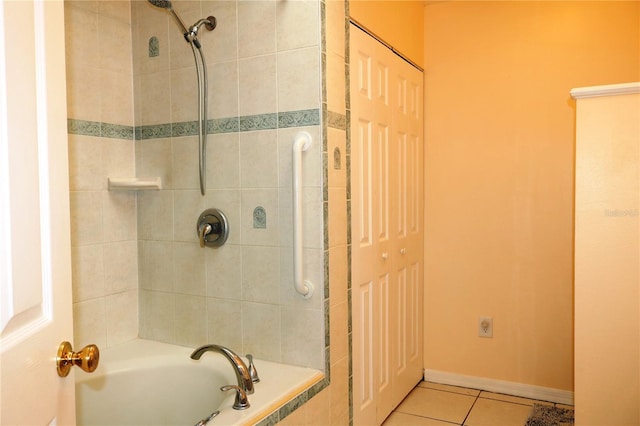 bathroom featuring tiled shower / bath combo and tile patterned flooring