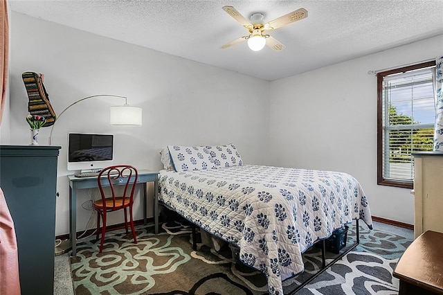 carpeted bedroom featuring ceiling fan and a textured ceiling