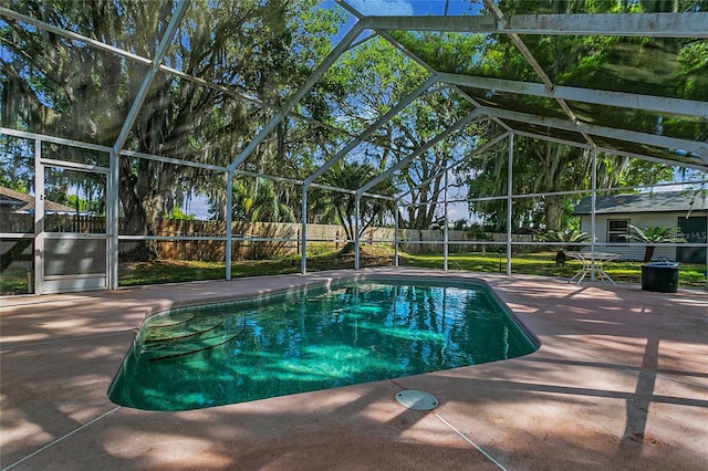 view of pool with a patio and glass enclosure