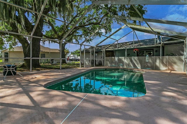 view of pool with a patio area and glass enclosure