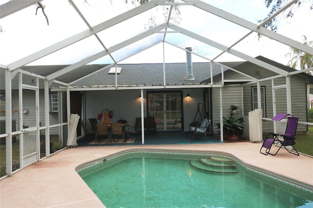 rear view of house featuring a patio area and glass enclosure