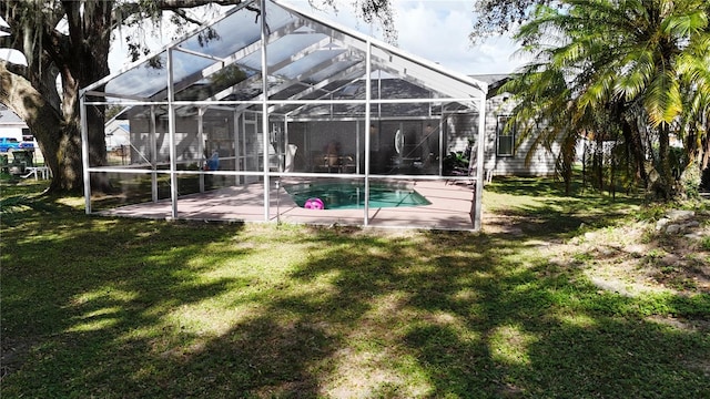 rear view of property featuring a patio area, a lanai, and a lawn