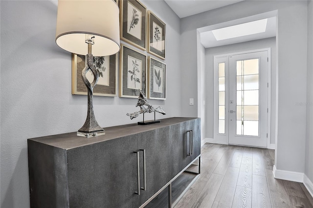 entryway with hardwood / wood-style floors and a skylight