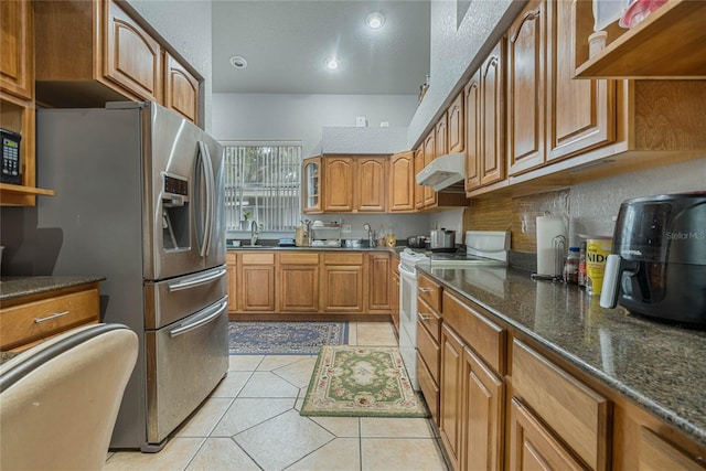 kitchen with decorative backsplash, dark stone countertops, light tile patterned flooring, sink, and stainless steel appliances