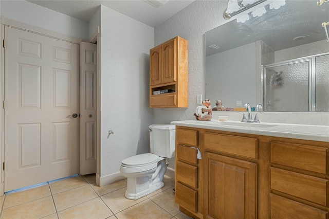 bathroom featuring vanity, toilet, tile patterned flooring, and a shower with door