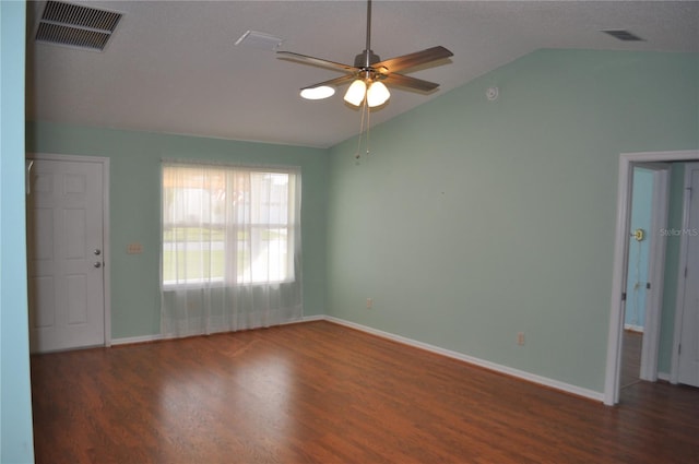 spare room with dark hardwood / wood-style floors, ceiling fan, a textured ceiling, and vaulted ceiling