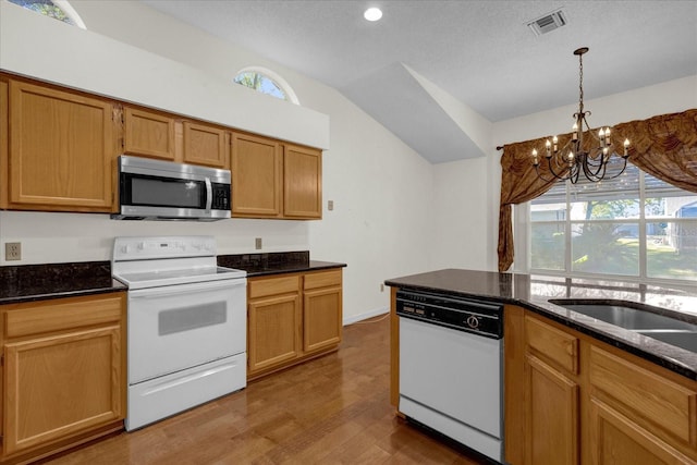 kitchen featuring white appliances, a textured ceiling, lofted ceiling, dark wood-type flooring, and a chandelier