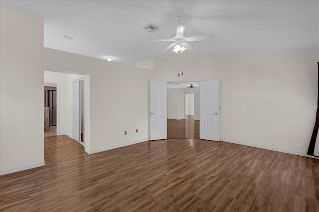 empty room with dark wood-type flooring, vaulted ceiling, and ceiling fan