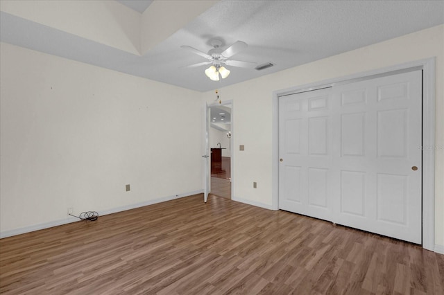 unfurnished bedroom with light hardwood / wood-style flooring, a textured ceiling, a closet, and ceiling fan