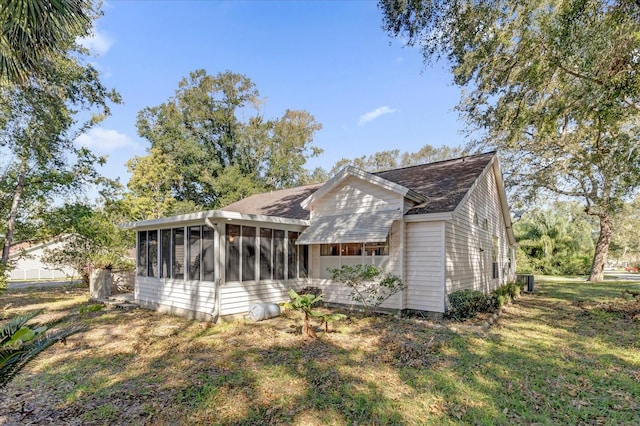 back of property with a lawn and a sunroom