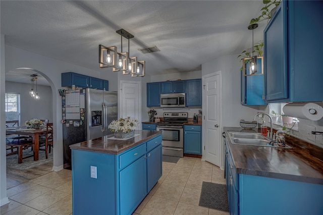 kitchen with blue cabinetry, light hardwood / wood-style floors, appliances with stainless steel finishes, and sink