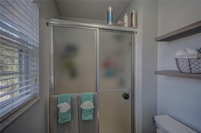 bathroom with walk in shower, a textured ceiling, and toilet