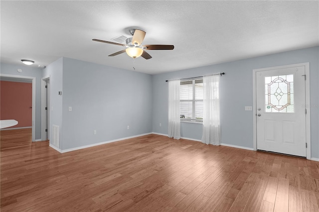 entrance foyer featuring light wood-type flooring, baseboards, visible vents, and a ceiling fan