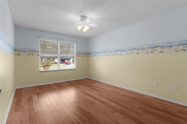 unfurnished room featuring baseboards, a textured ceiling, a ceiling fan, and wood finished floors