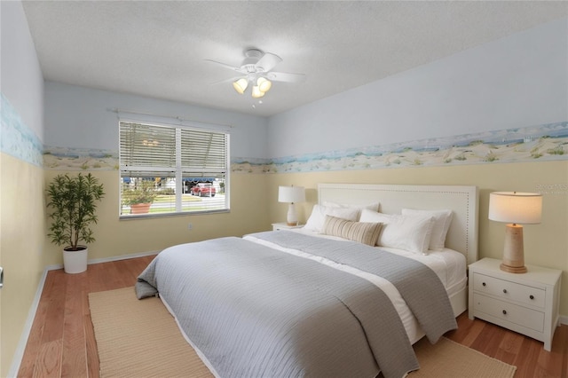 bedroom with baseboards, ceiling fan, a textured ceiling, and light wood-style floors