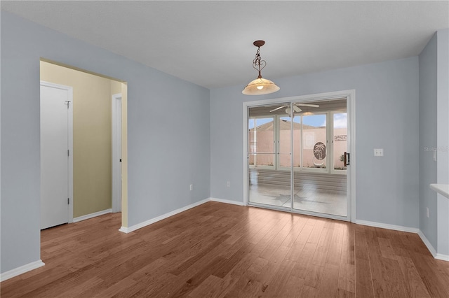 unfurnished dining area with wood finished floors and baseboards