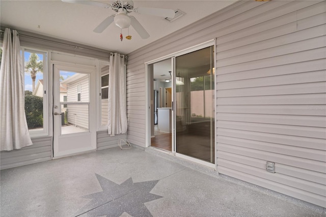 unfurnished sunroom featuring a ceiling fan