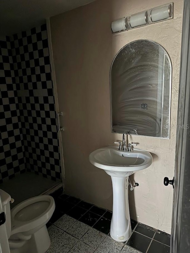 bathroom featuring tile patterned floors, toilet, and walk in shower