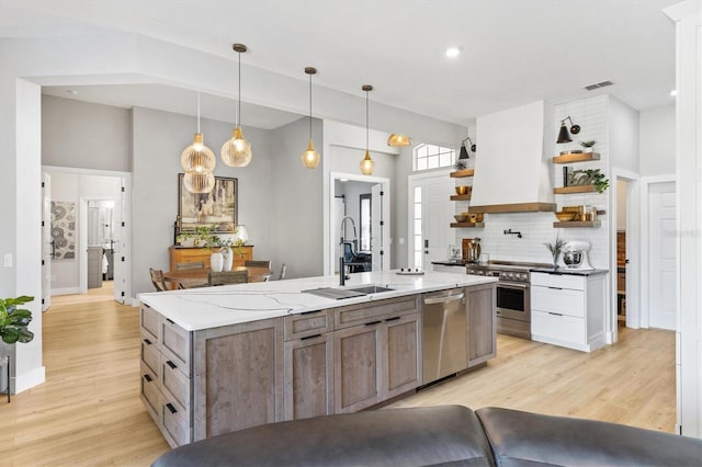 kitchen featuring sink, white cabinetry, stainless steel appliances, and light wood-type flooring