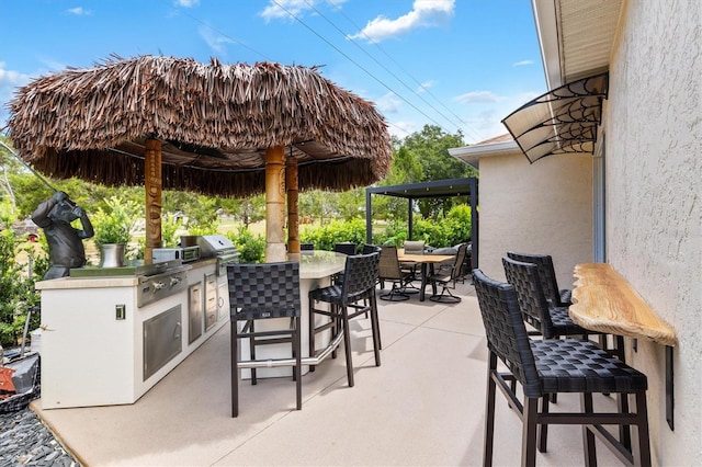 view of patio / terrace with a gazebo, area for grilling, an outdoor bar, and an outdoor kitchen