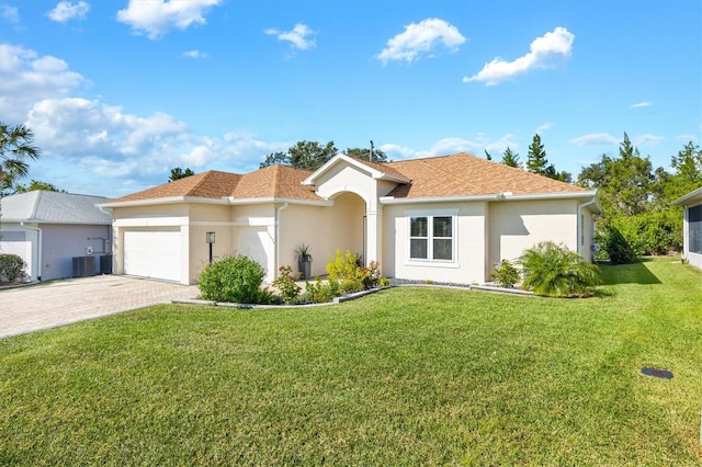 view of front of home featuring a front lawn, central AC unit, and a garage