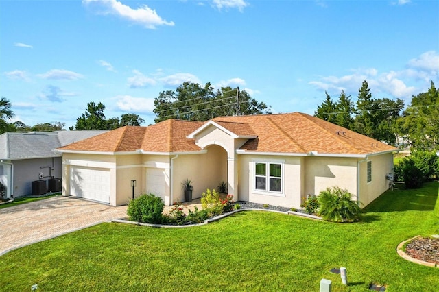 view of front of house with cooling unit, a front yard, and a garage