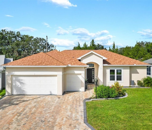 ranch-style house with a garage and a front lawn