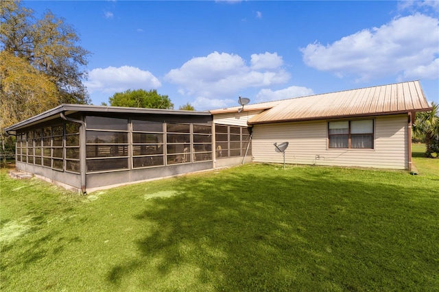 back of property with a lawn and a sunroom