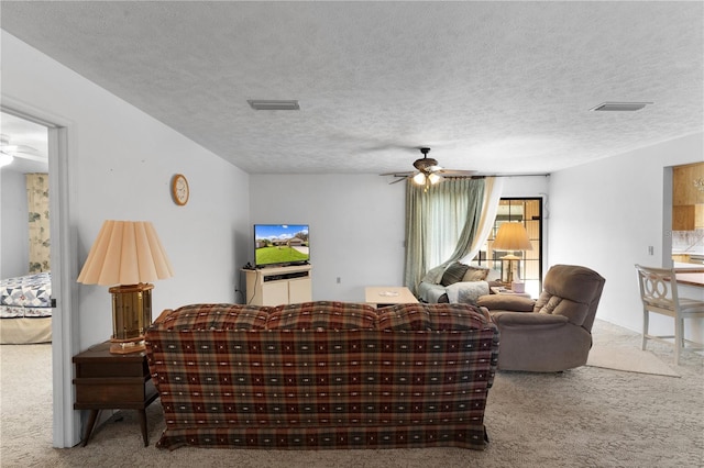 carpeted living room featuring a textured ceiling and ceiling fan