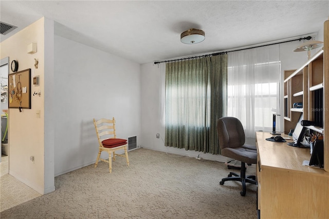 home office featuring a textured ceiling and carpet flooring