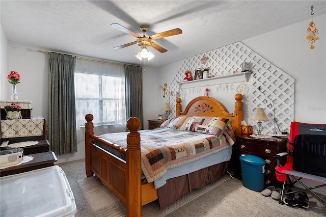 carpeted bedroom featuring ceiling fan and a textured ceiling