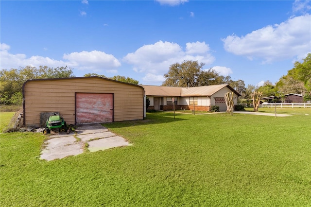 back of house featuring a yard, an outbuilding, and a garage