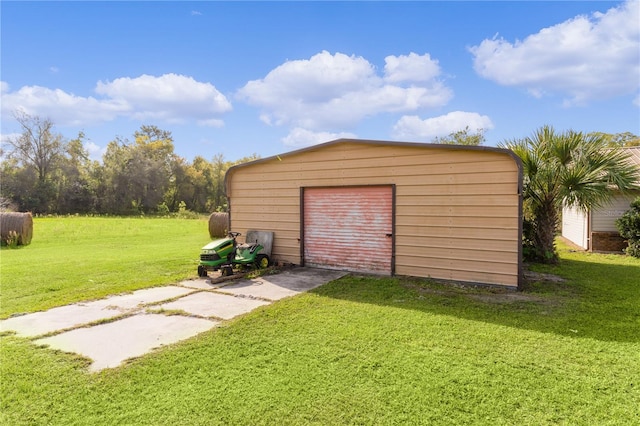 view of outdoor structure with a yard and a garage