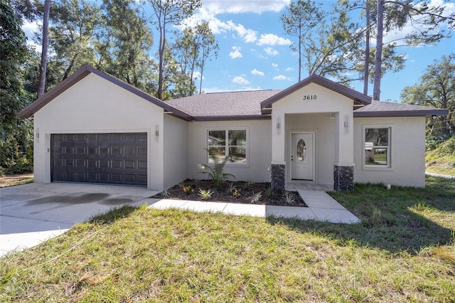 view of front of house featuring a garage, driveway, a front yard, and stucco siding