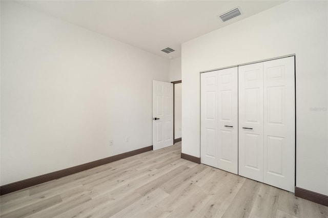 unfurnished bedroom with light hardwood / wood-style floors and a closet