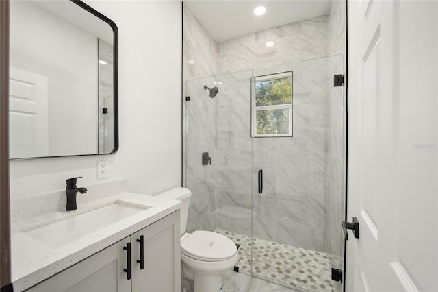 bathroom with recessed lighting, toilet, vanity, and a marble finish shower