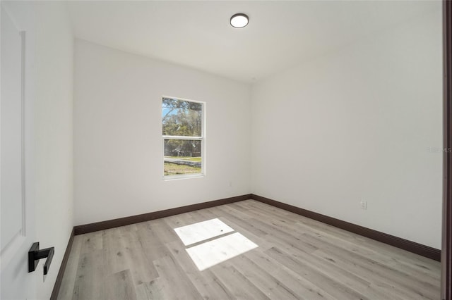 unfurnished room with light wood-style flooring and baseboards