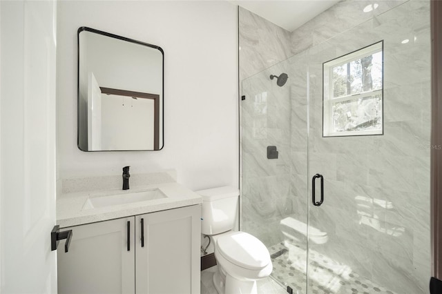 bathroom with vanity, a shower with shower door, and toilet