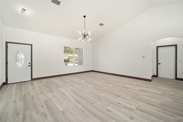 unfurnished living room featuring a notable chandelier, high vaulted ceiling, and light wood-type flooring