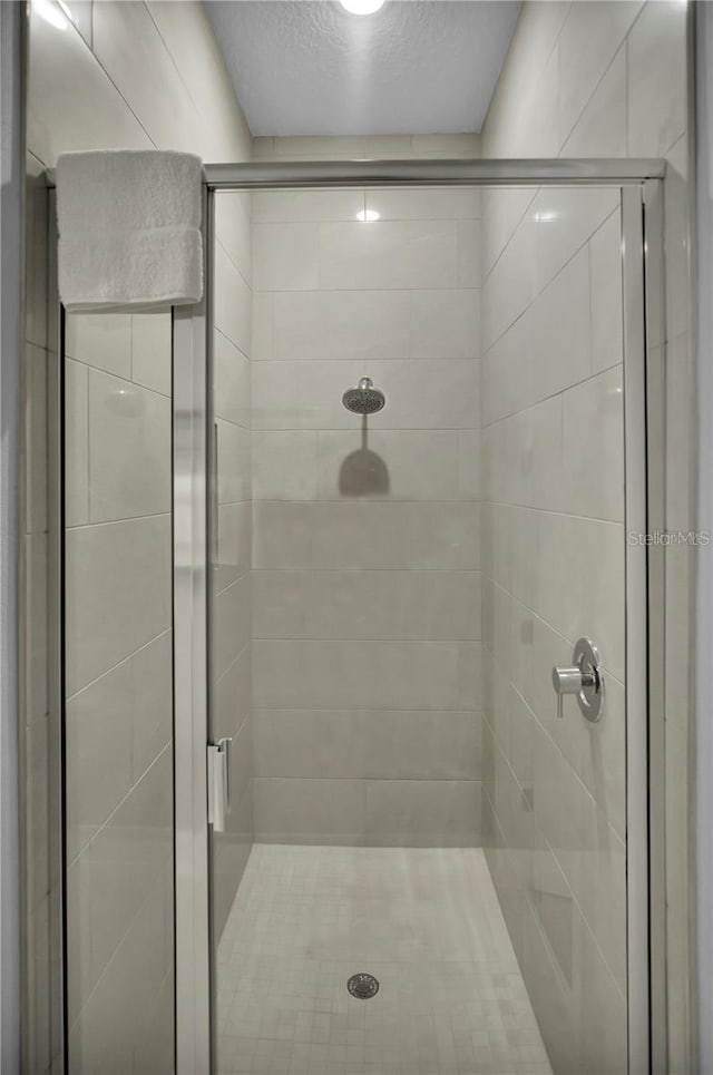 bathroom featuring a textured ceiling and an enclosed shower