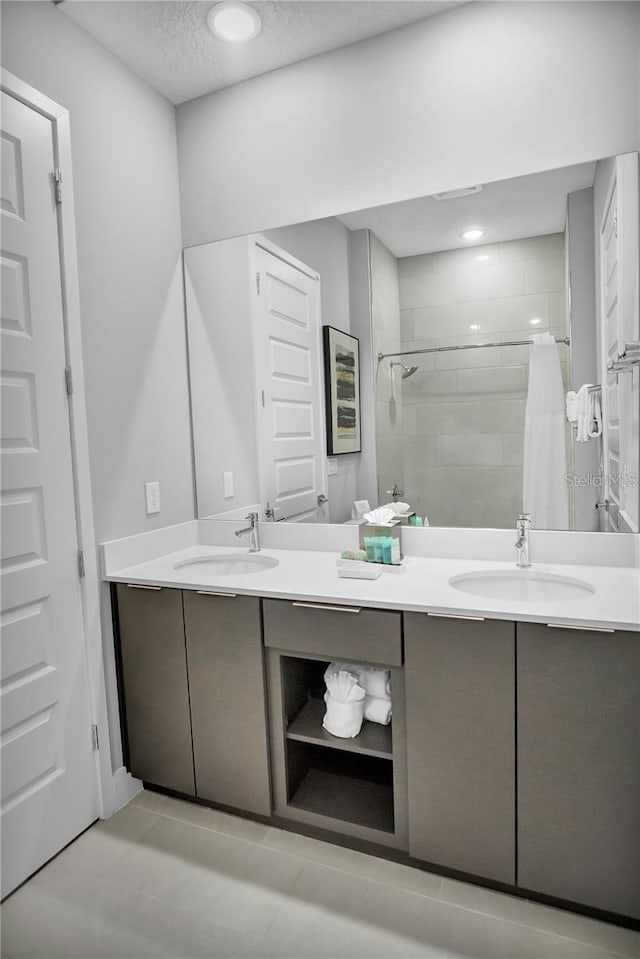 bathroom with vanity, a shower with shower curtain, and a textured ceiling