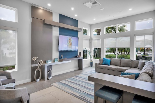 living room with a towering ceiling and light hardwood / wood-style floors