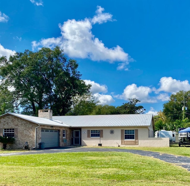 single story home featuring a garage and a front lawn