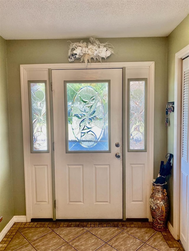 entryway with tile patterned floors and a textured ceiling