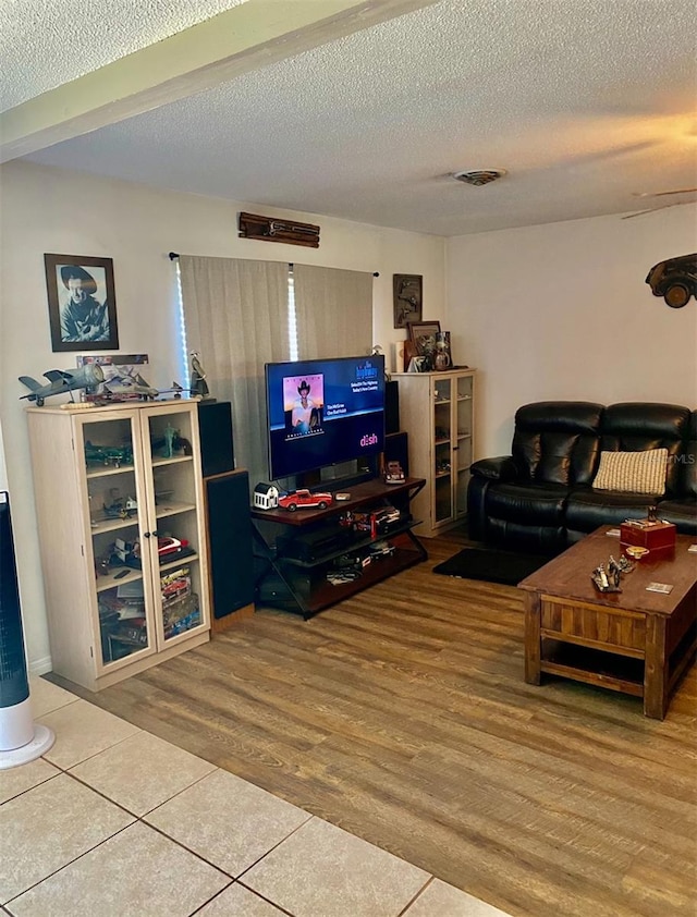 living room featuring wood-type flooring and a textured ceiling