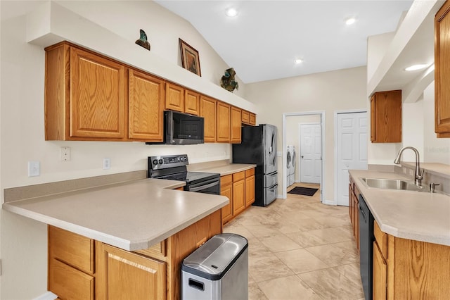 kitchen featuring black appliances, sink, separate washer and dryer, kitchen peninsula, and lofted ceiling