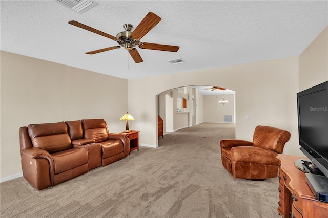 living room with ceiling fan with notable chandelier, a textured ceiling, and light colored carpet