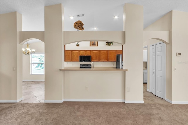 kitchen featuring light carpet, stainless steel appliances, and kitchen peninsula